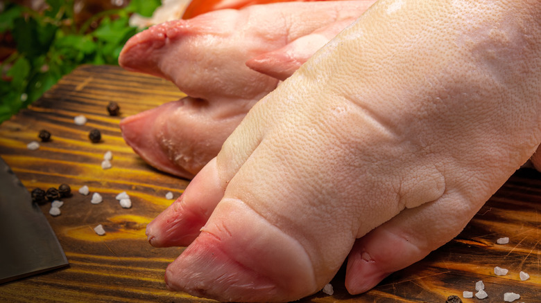 raw pig feet on cutting board