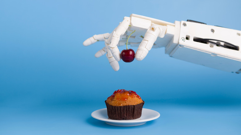 robot hand and cupcake