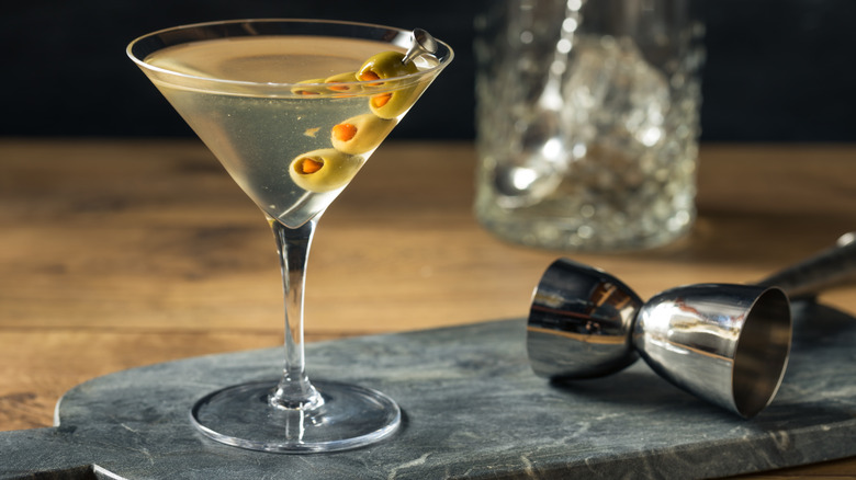 Dirty martini next to cocktail jigger