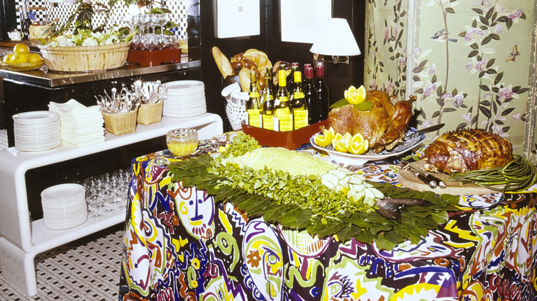 Platters of food arranged on table in 1970s kitchen