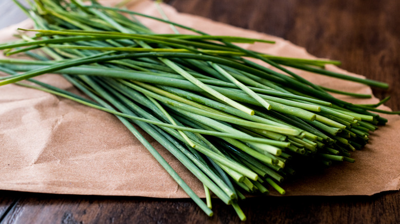 fresh chives on a paper and wood table
