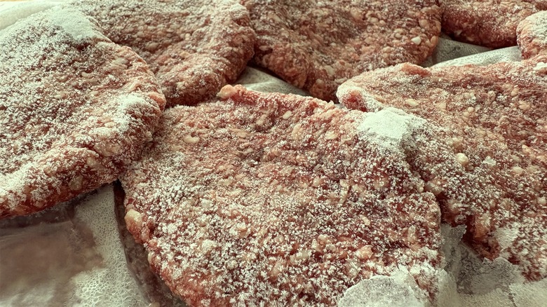Frozen hamburgers with a slight greenish hue.