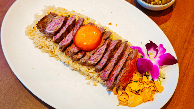 Medium-rare steak with an egg on top with a slightly purple hue