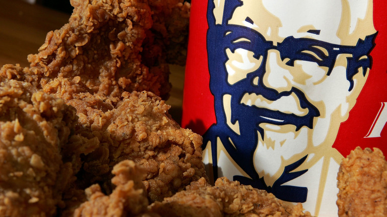 A close-up of a KFC logo with pieces of crispy fried chicken