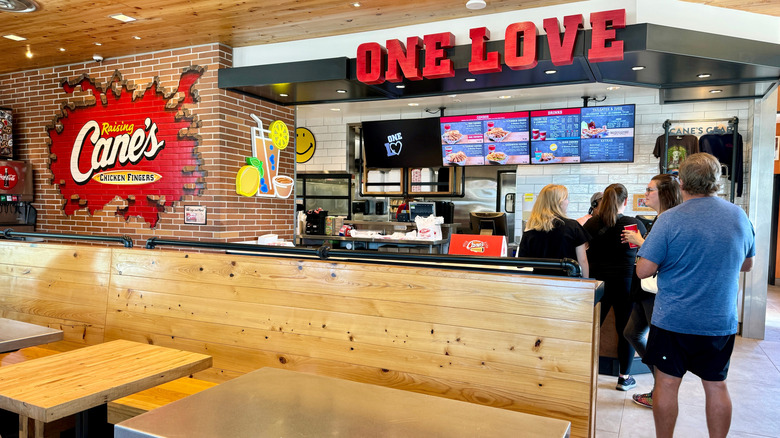 Customers waiting in line inside Raising Cane's lobby.