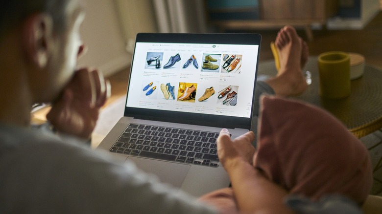 man at home shopping online with laptop