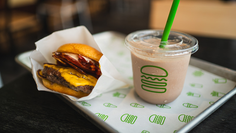 A Shake Shack tray with a burger and small milkshake