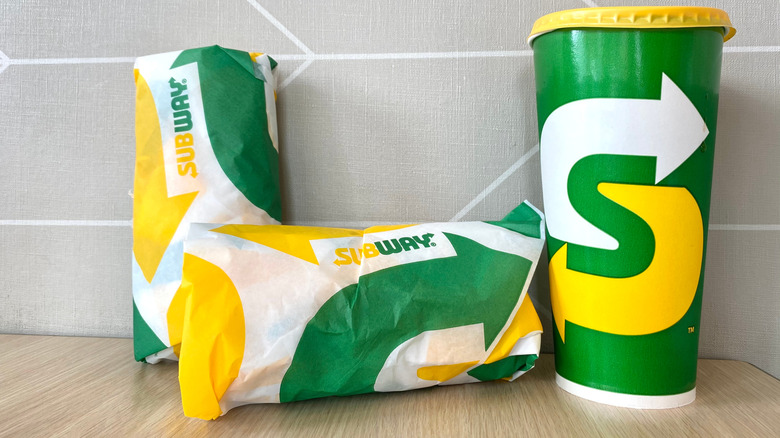Subway sandwiches and drink on counter.