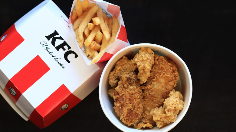 KFC meal with bucket of chicken and bag of french fries.