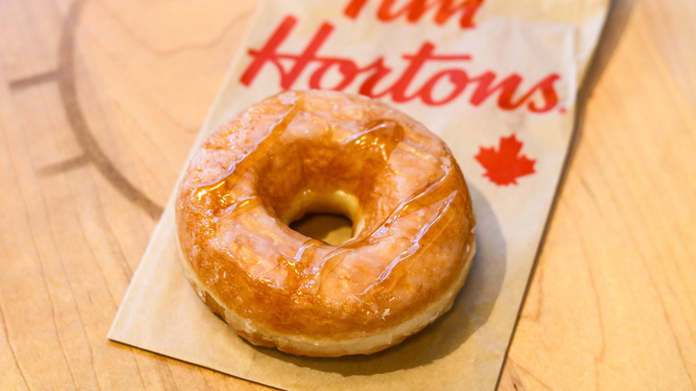 A Tim Hortons glazed donut atop a branded napkin