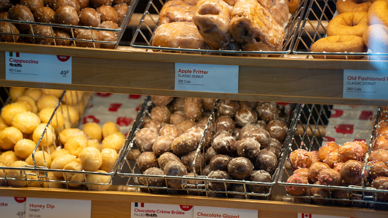 A variety of Tim Hortons donuts and Timbits fill a display case.