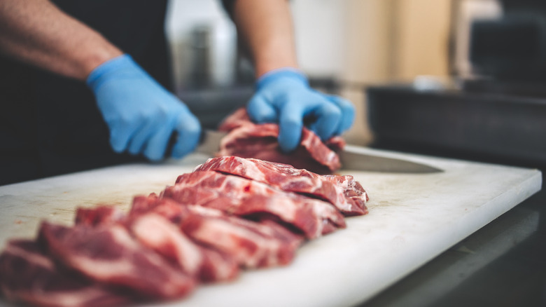 butcher cutting raw steak