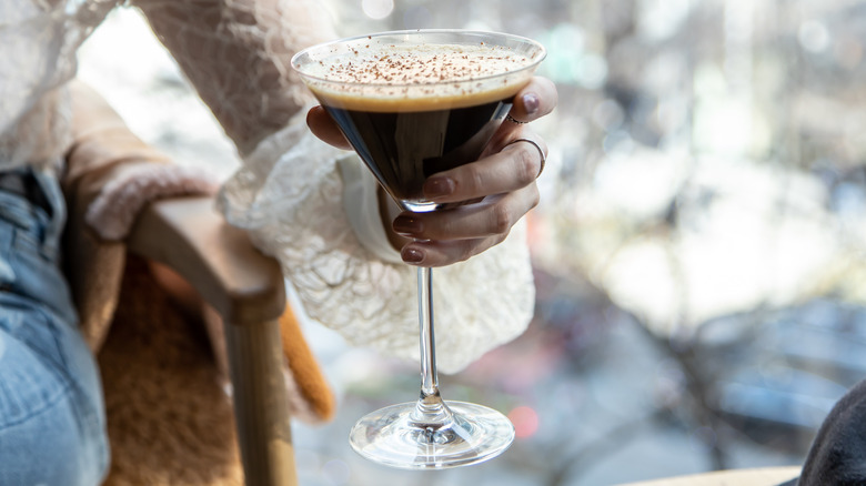 woman holding chocolate liqueur drink
