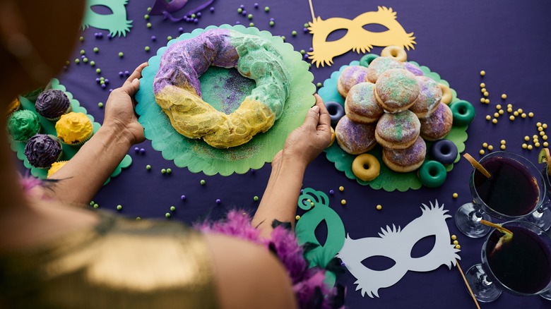 Person serving Mardi Gras desserts 