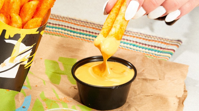 Nacho Fries dipping in cheese cause