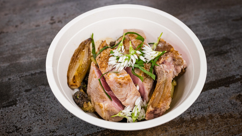 Bowl of sliced veal with edible flowers