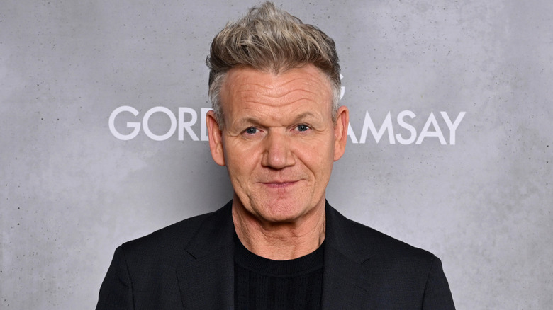Gordon Ramsay smiling for cameras at a publicity event.
