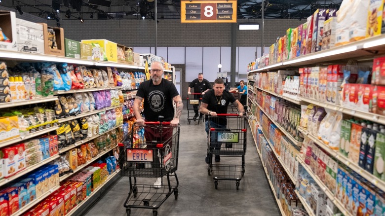 Contestants in aisles with carts looking for ingredients