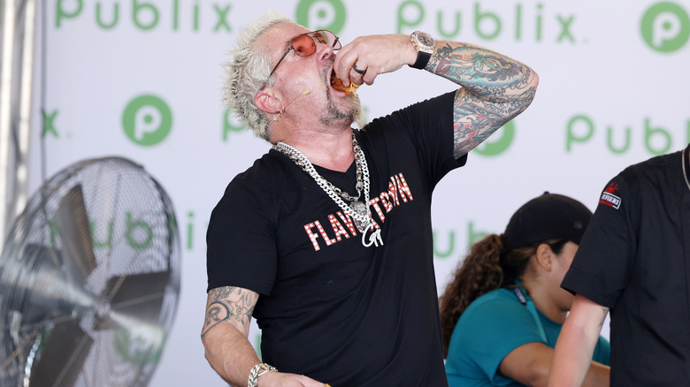 Guy Fieri eating onstage at an event