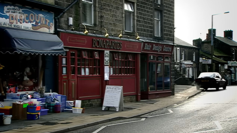 A street in Silsden, UK with signs for a discount store, Bonapartes restaurant, and Hair Design Centre