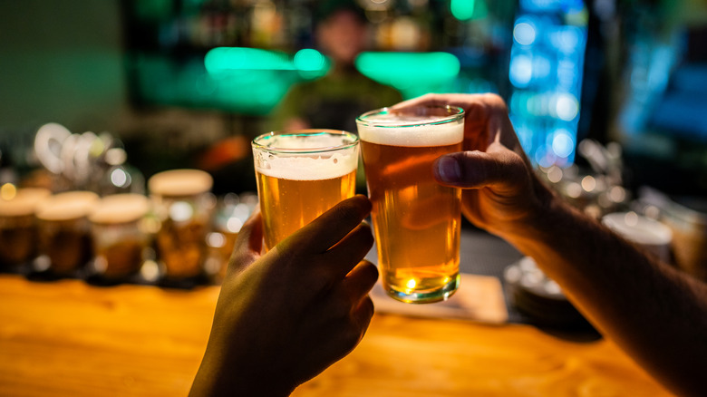Cheering two pints of beer in a bar