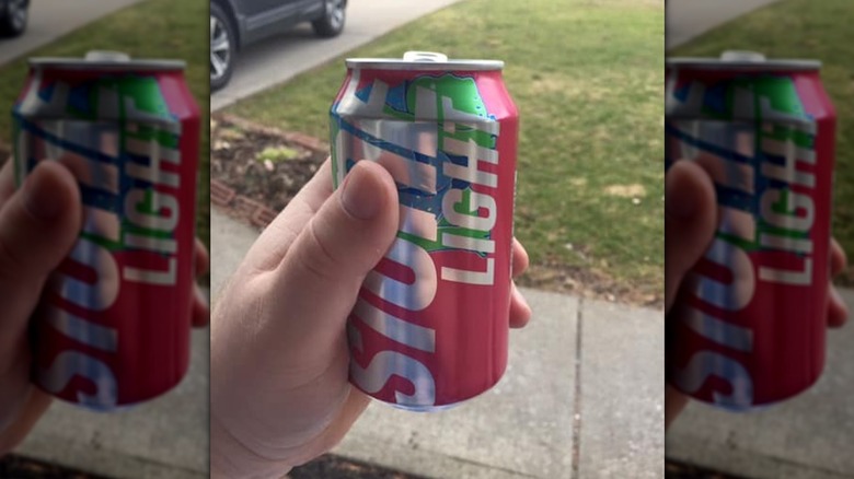 Person holding a can of Keystone Light fruit-flavored beer, Keylightful