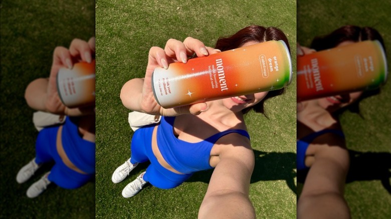 Person holding a can of Moment