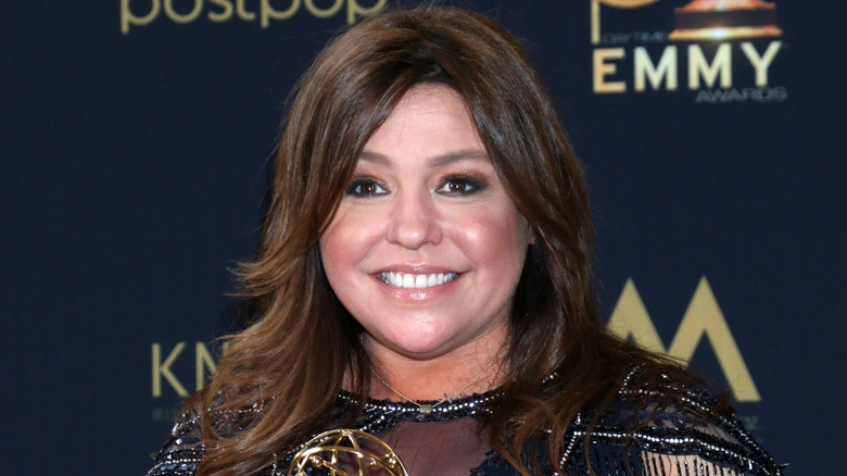 Rachael Ray smiling for cameras at publicity event.