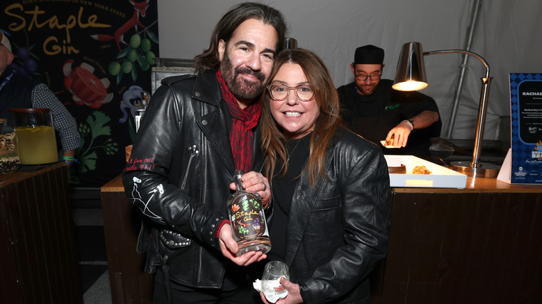 Rachael Ray and husband John Cusimano holding a bottle of Staple Gin.