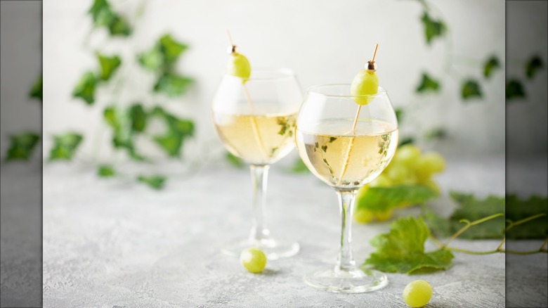 Two glasses of wine spritzer with grape garnishes