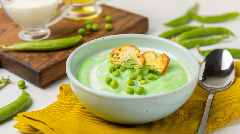 Bowl of green pea soup with croutons