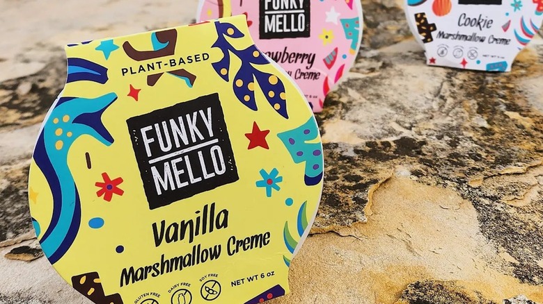 Containers of Funky Mello marshmallow creme on beach