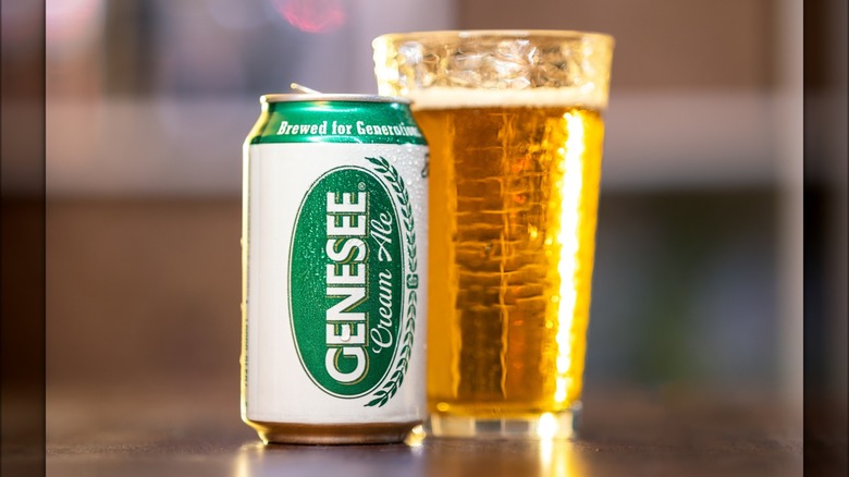Can of Genesee cream ale next to full glass of beer.