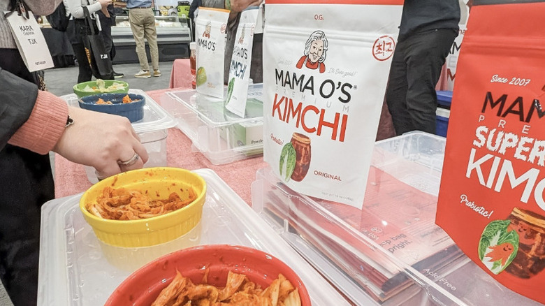 Mama O's Kimchi at a display table with bowls of kimchi before the bags.