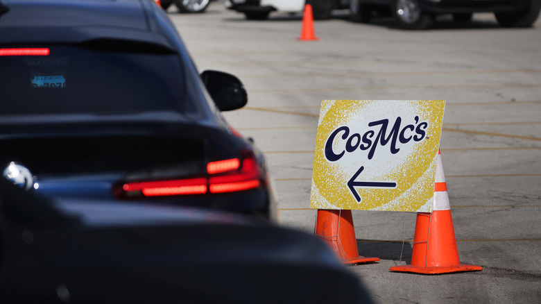 A CosMc's sign at a drive thru location directing cars