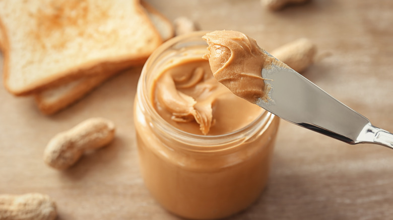 Peanut butter from jar on a knife