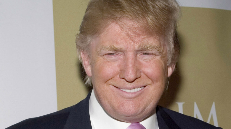 Trump smiling with gold and white background