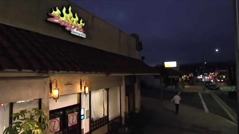 A shot of Zayna Flaming Grill's exterior at night, as Gordon Ramsay walks away.