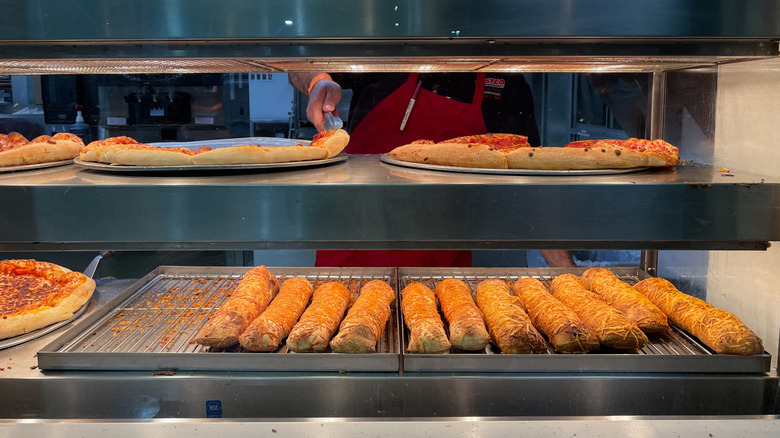 Chicken bakes and pizza being prepared inside Costco's food court