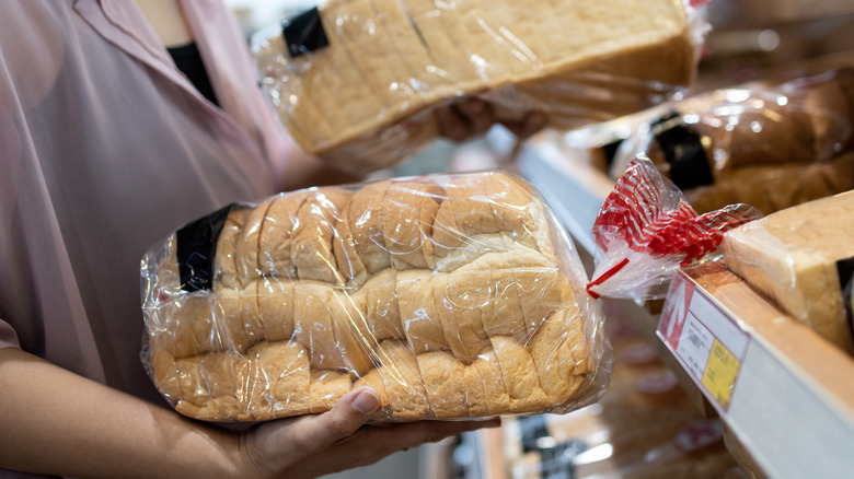person shopping for bread in grocery store