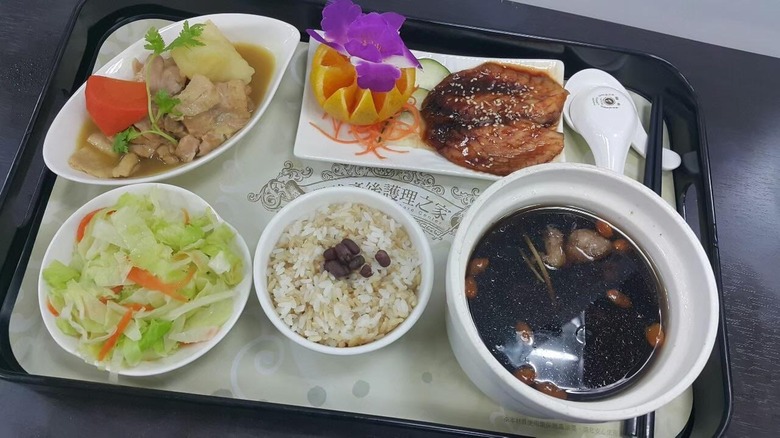 Hospital tray with grilled fish, herbal pork rib soup, salad, and rice.