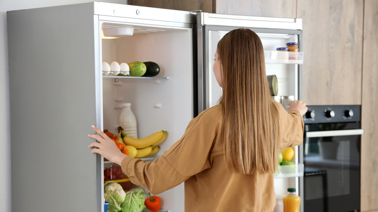 Person looking into fridge in home kitchen