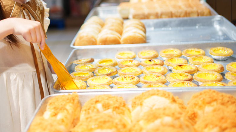 Child browsing tray of milk tarts