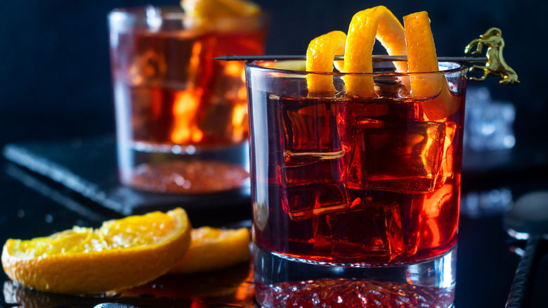 Two negronis in glasses with orange peel twist