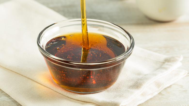 dark agave syrup being poured into small glass bowl