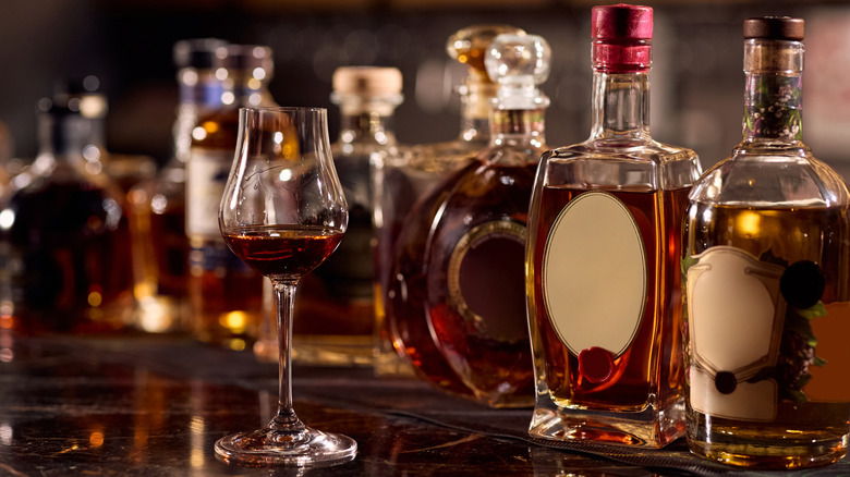 Unlabeled bottles of bourbon and a tasting flute