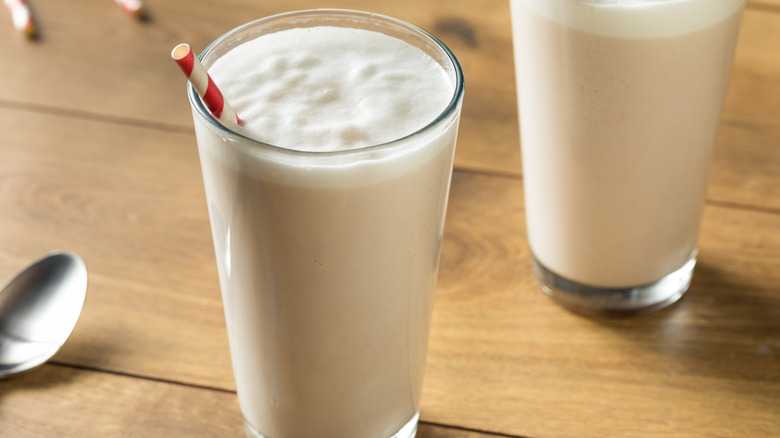 Homemade chocolate egg cream in glasses with striped drinking straw