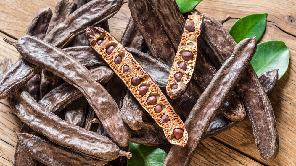 Carob pods on wooden surface