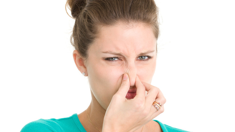 woman holding her nose