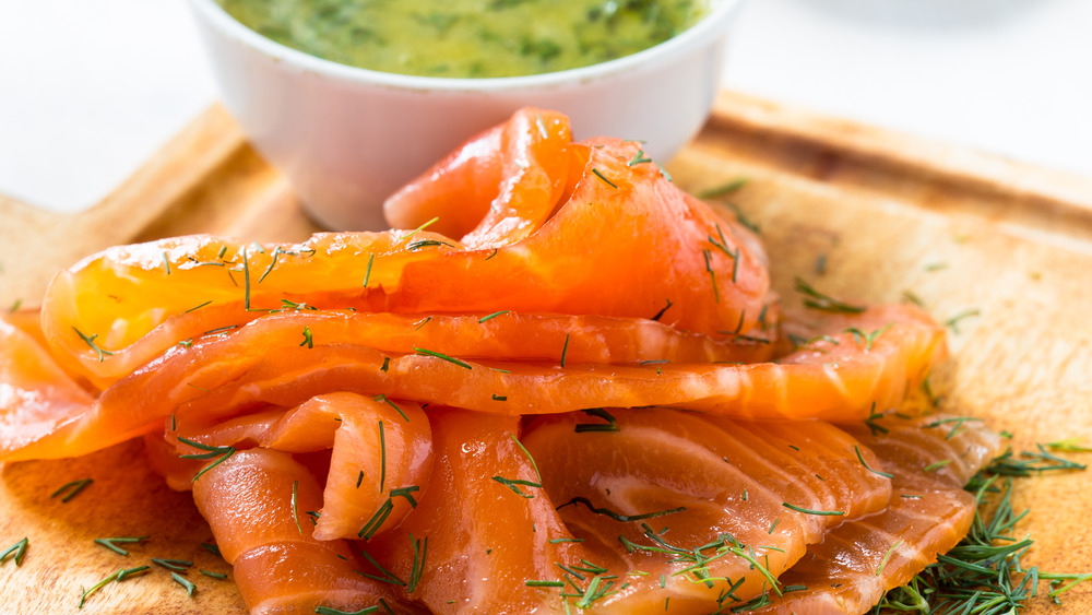 Gravlax covered in dill with mustard sauce in background